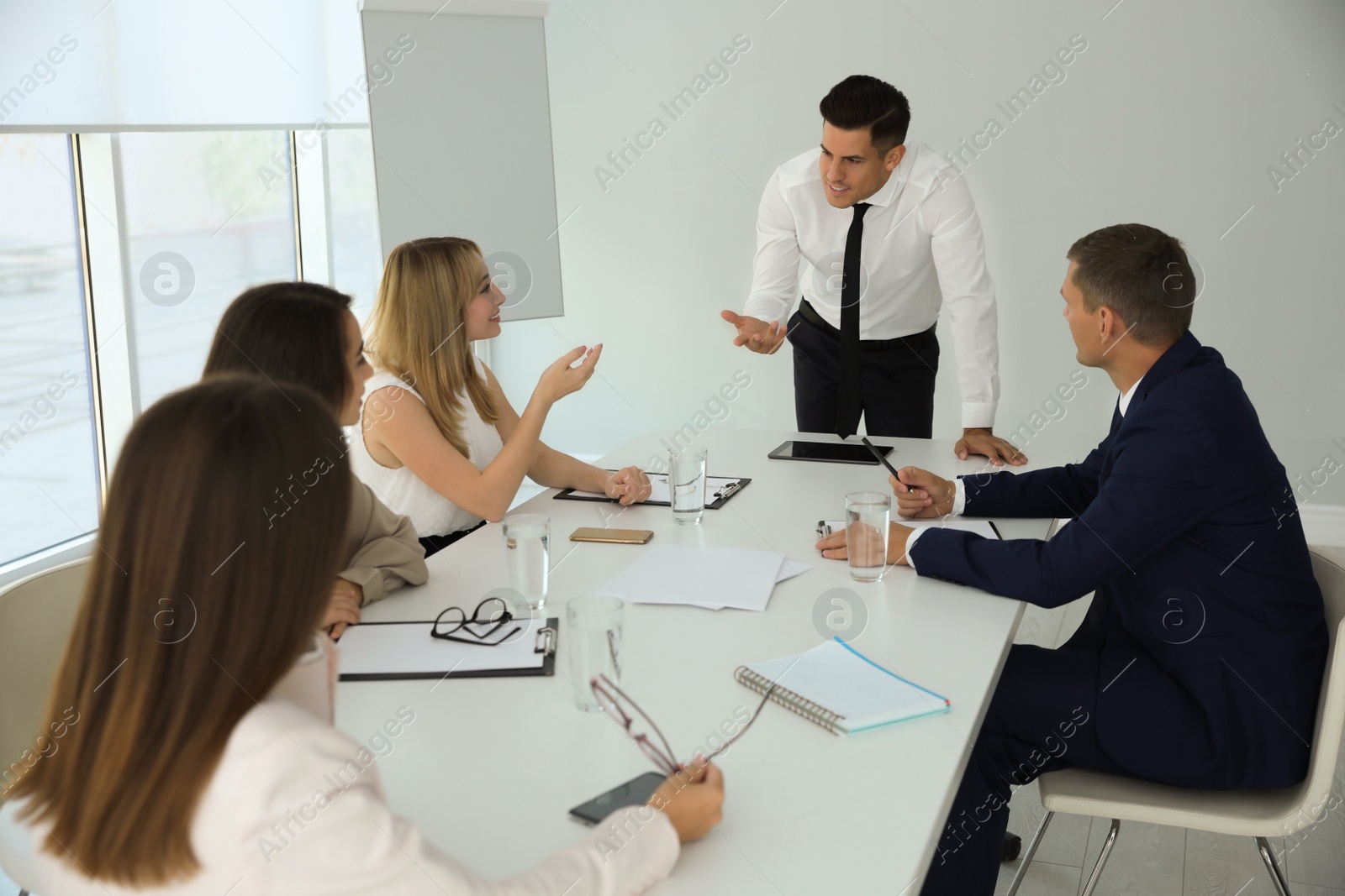 Photo of Office employees talking at table during meeting