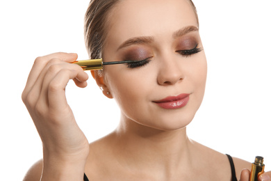 Beautiful woman applying eyeliner on white background. Stylish makeup
