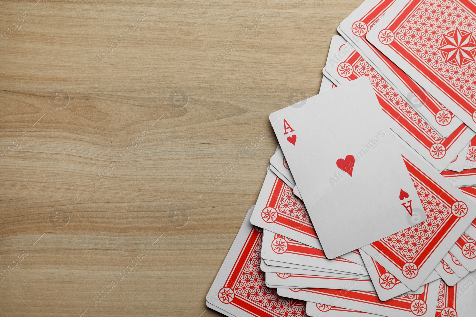 Photo of Deck of playing cards on wooden table, flat lay. Space for text