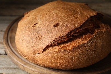 Photo of Freshly baked sourdough bread on wooden table, closeup