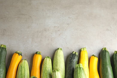 Photo of Fresh ripe zucchinis on grey table, flat lay. Space for text