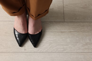 Businesswoman in leather shoes on floor, above view. Space for text