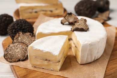 Photo of Soft cheese and fresh truffles on table, closeup