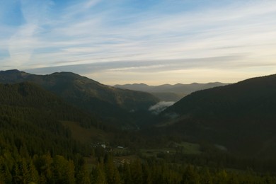 Aerial view of beautiful mountain landscape with village and green trees in morning