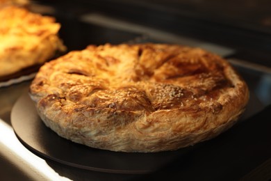 Photo of Delicious pie with tasty filling on counter in bakery shop, closeup