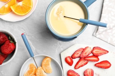 Photo of Flat lay composition with white chocolate fondue on grey marble background