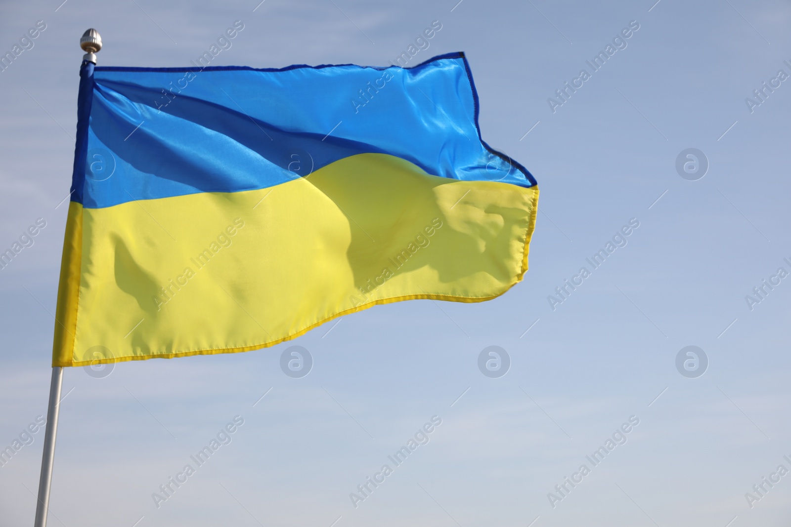 Photo of National flag of Ukraine against blue sky, closeup