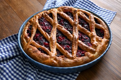 Photo of Delicious currant pie and towel on wooden table