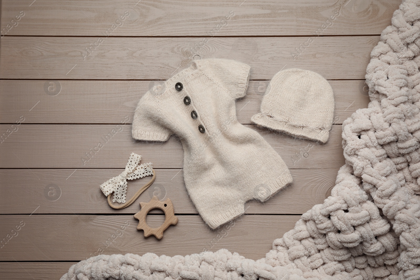 Photo of Flat lay composition with cute baby knitwear for photoshoot on wooden background