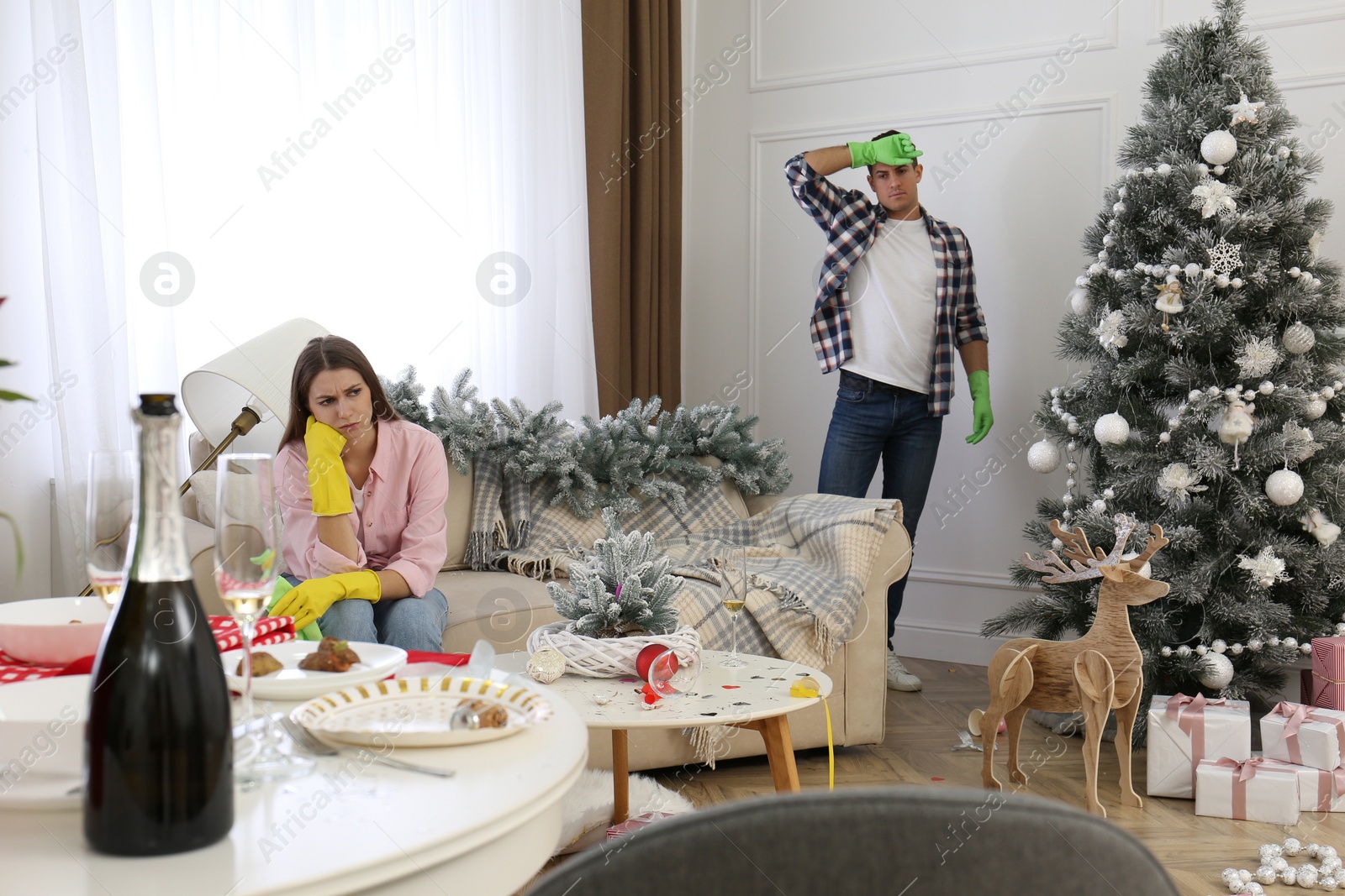 Photo of Couple cleaning messy room after New Year party