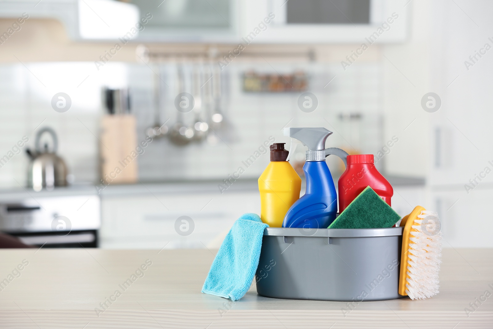 Photo of Basin with cleaning supplies on table indoors