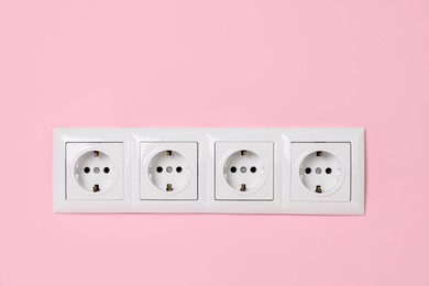 Power sockets on pink wall. Electrical supply