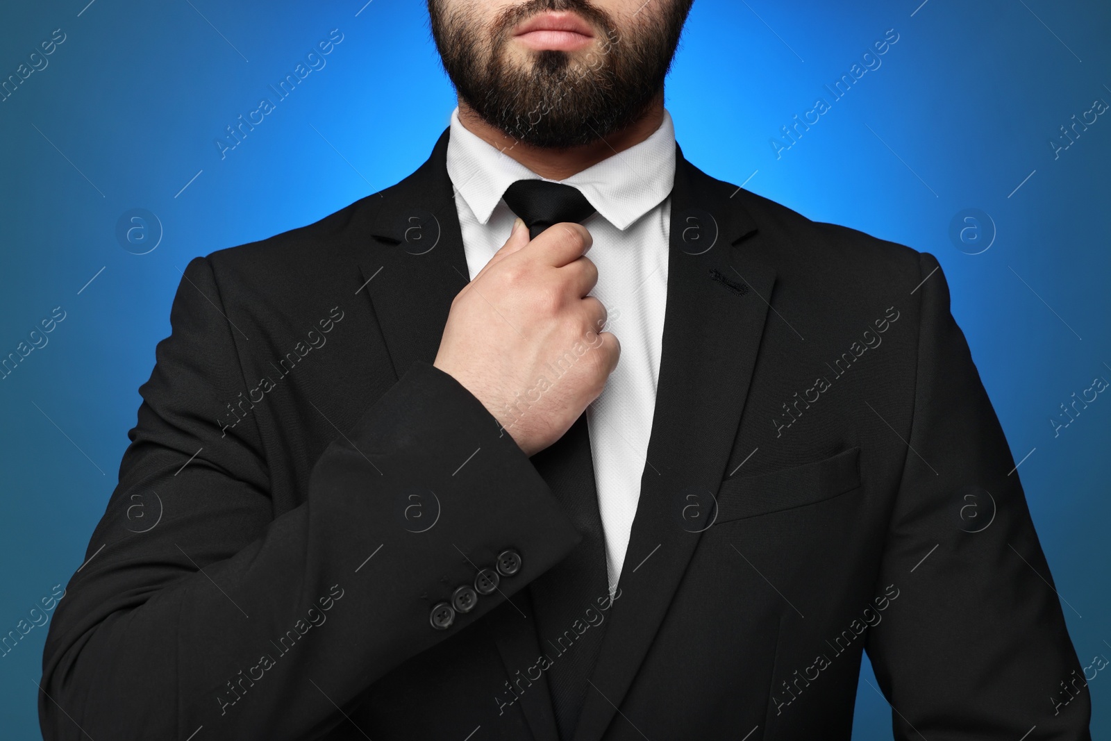 Photo of Businessman in suit and necktie on blue background, closeup