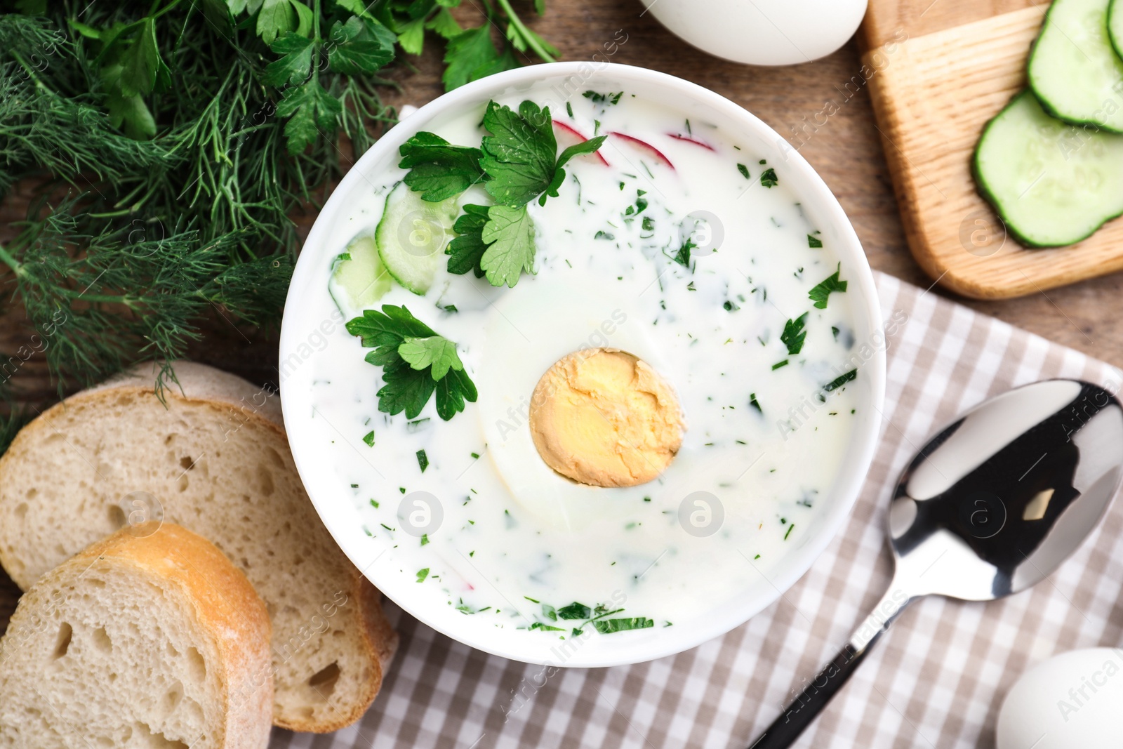 Photo of Delicious cold summer soup with kefir served on wooden table, flat lay