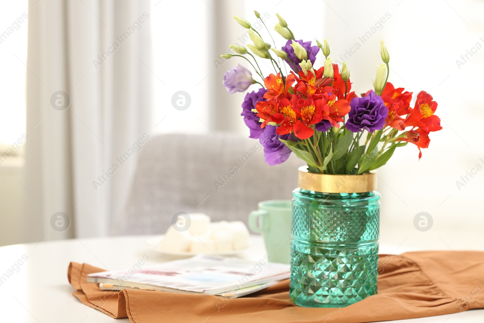 Photo of Glass vase with fresh flowers and magazines on table indoors. Space for text