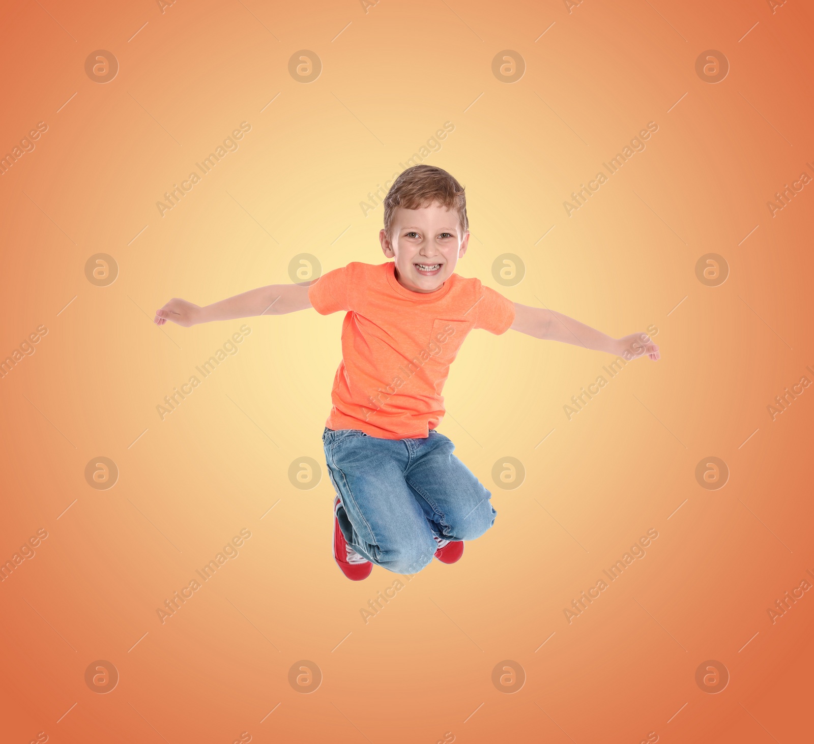 Image of Happy boy jumping on color gradient background