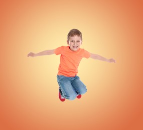 Image of Happy boy jumping on color gradient background