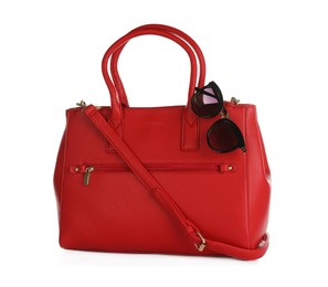 Photo of Red women's bag and sunglasses on white background