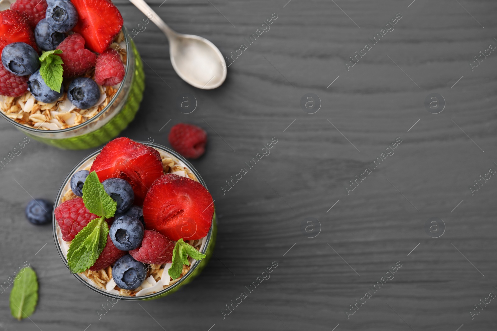 Photo of Tasty oatmeal with smoothie, berries and mint on grey wooden table, flat lay. Space for text. Healthy breakfast