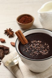 Photo of Yummy hot chocolate with cinnamon in cup on white wooden table