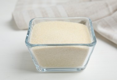 Gelatin powder in glass bowl on white table, closeup