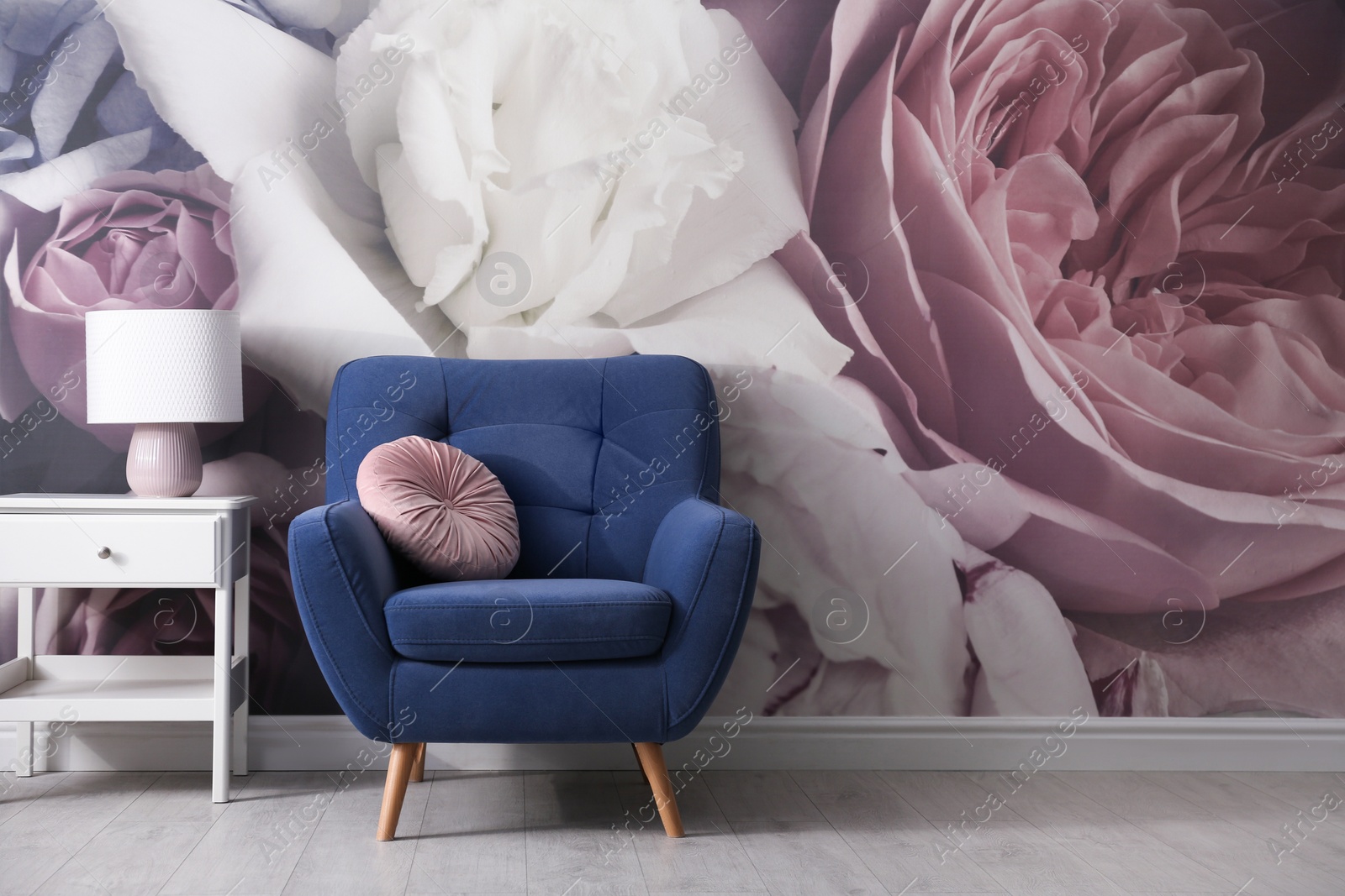 Photo of Comfortable armchair near wall with floral wallpaper. Stylish living room interior