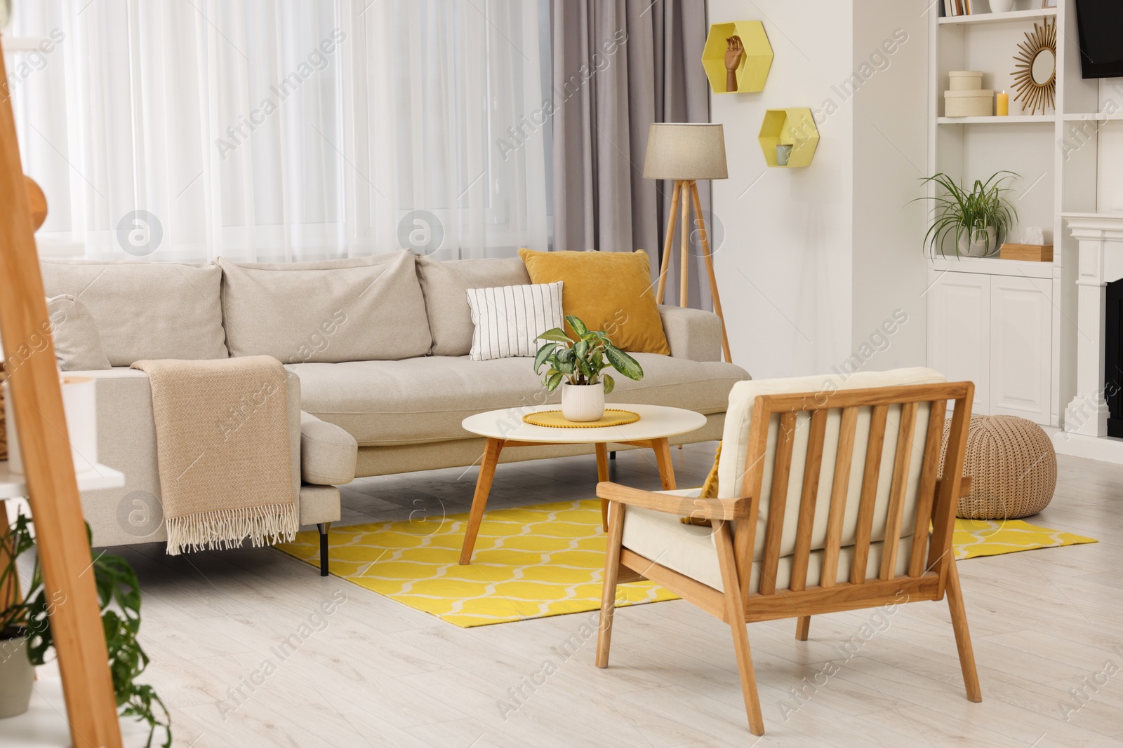 Photo of Spring atmosphere. Stylish room interior with cozy furniture in yellow and white colors