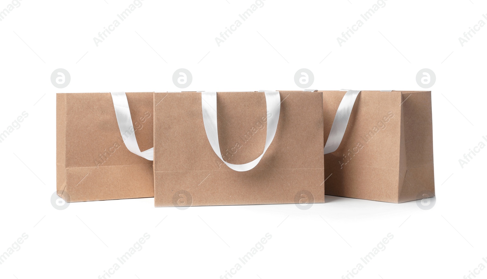 Photo of Paper shopping bags with ribbon handles on white background. Mockup for design