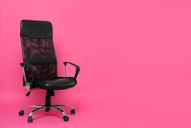 Photo of Comfortable office chair on pink background, space for text