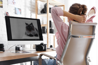 Photo of Professional photographer resting at table in office