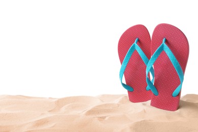 Pink flip flops in sand on white background