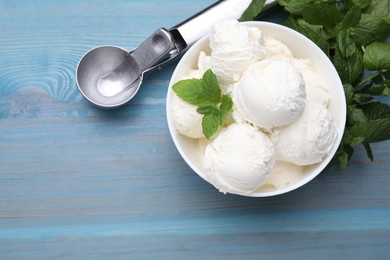 Photo of Delicious vanilla ice cream, mint and scoop on light blue wooden table, flat lay. Space for text