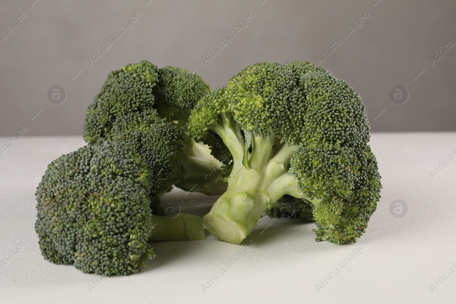 Photo of Fresh raw green broccoli on white table