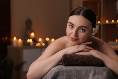 Photo of Spa therapy. Beautiful young woman lying on massage table in salon, space for text