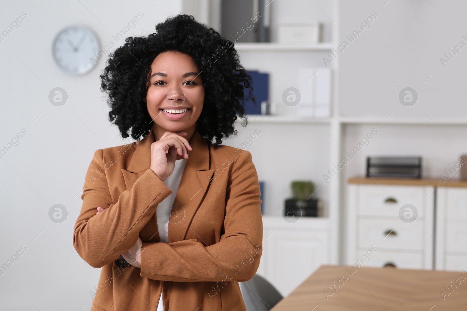 Photo of Smiling young businesswoman in office. Space for text