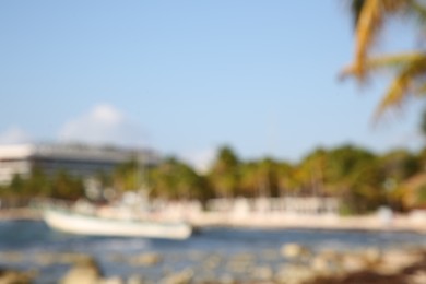 Photo of Blurred view of tropical beach and boat on sunny day