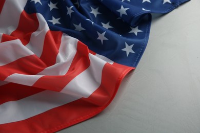 Photo of Flag of USA on light grey table, closeup. Space for text