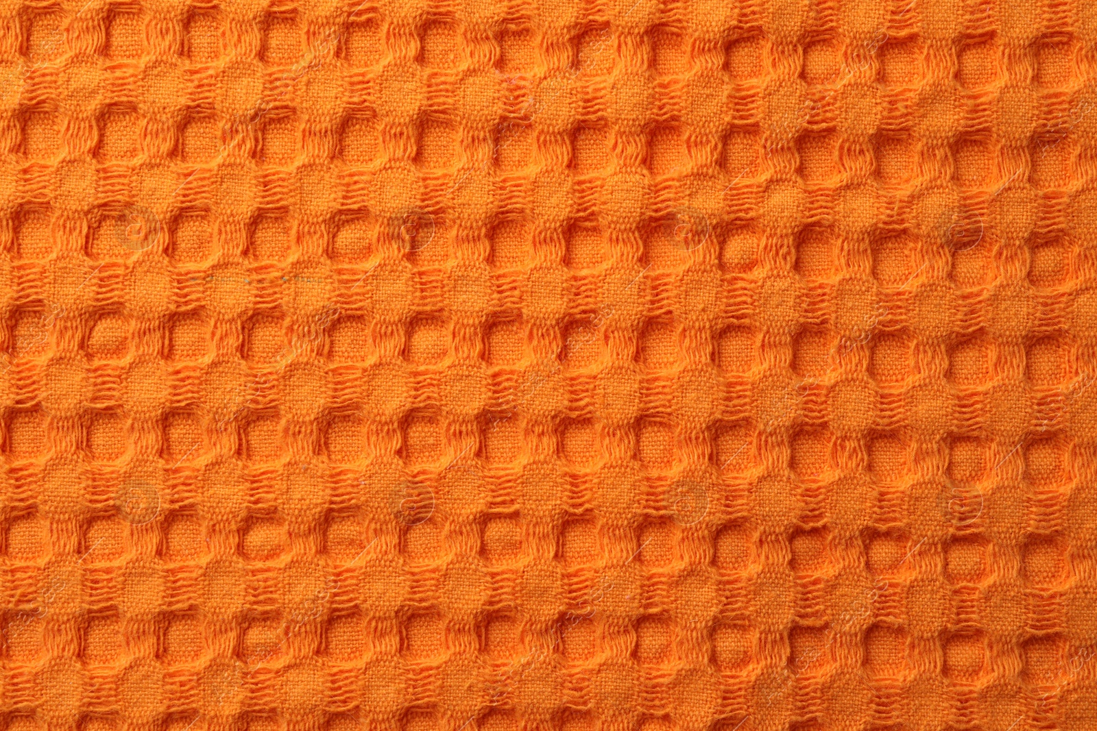 Photo of Texture of orange knitted fabric as background, top view