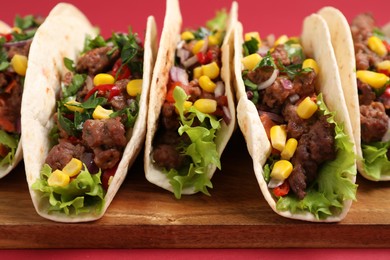 Photo of Delicious tacos with meat and vegetables on table, closeup