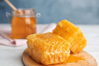 Photo of Fresh delicious honeycombs on white wooden table, closeup