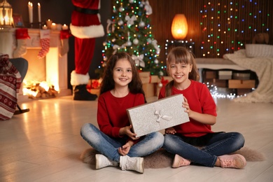 Photo of Little children with Christmas gift at home