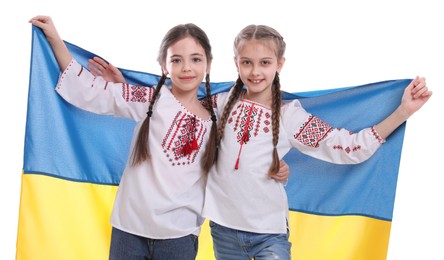 Photo of Happy girls in national clothes with flag of Ukraine on white background