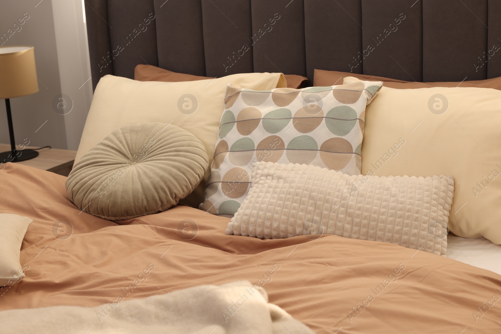 Photo of Large comfortable bed with soft pillows indoors. Home textile