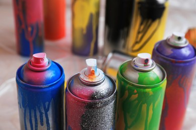 Photo of Used cans of spray paints indoors, closeup. Graffiti supplies
