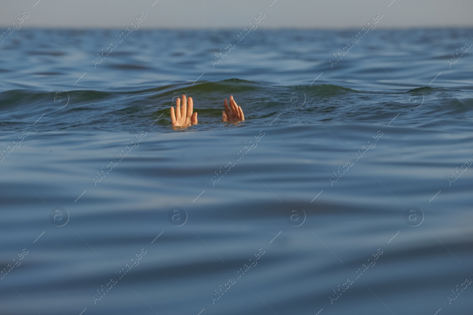 Photo of Drowning woman reaching for help in sea