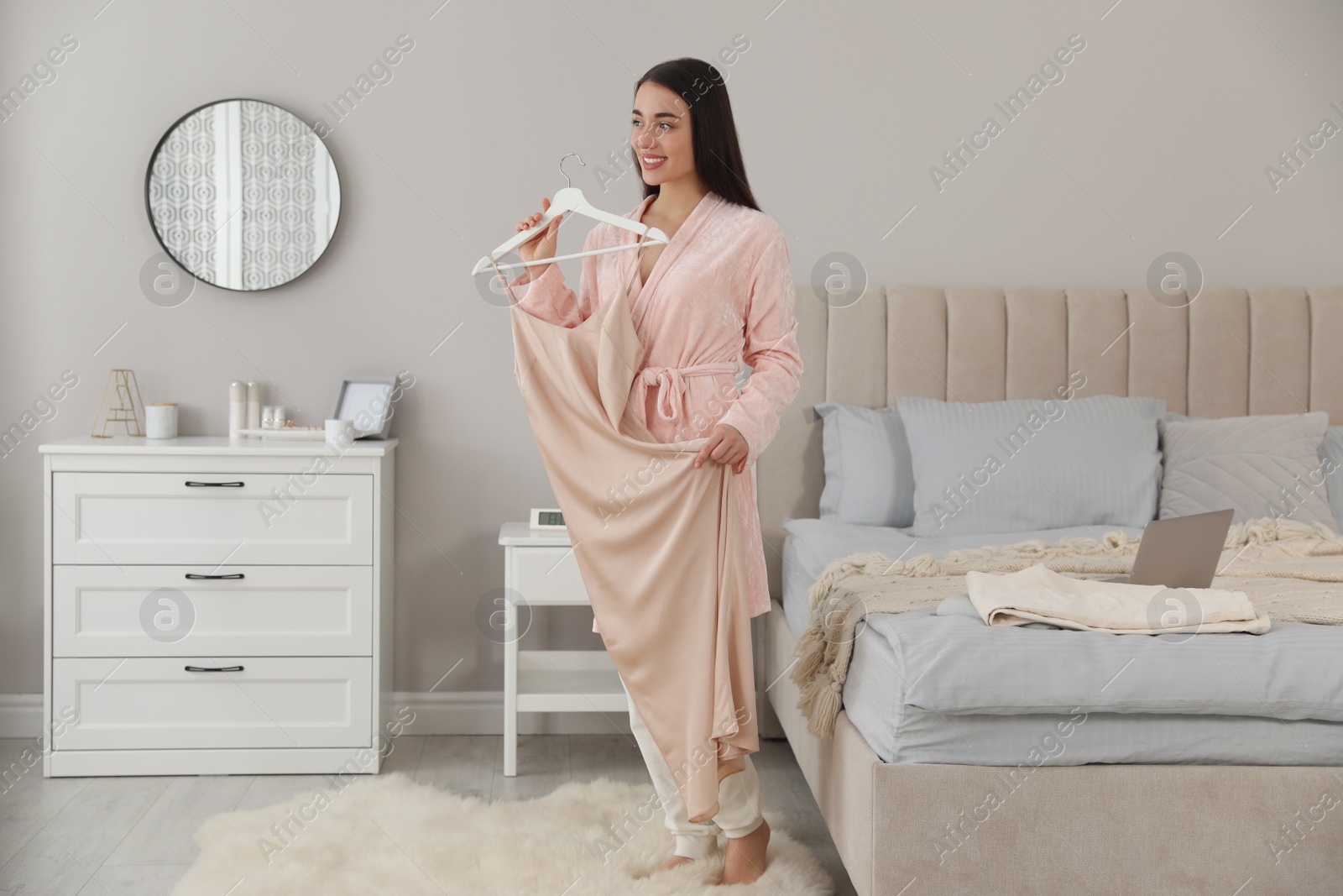 Photo of Young woman choosing clothes for work day at home. Morning routine