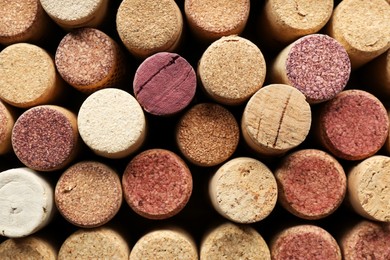 Photo of Many corks of wine bottles as background, top view