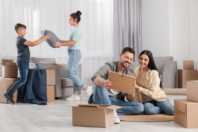 Photo of Happy family settling into new house and unpacking boxes. Moving day