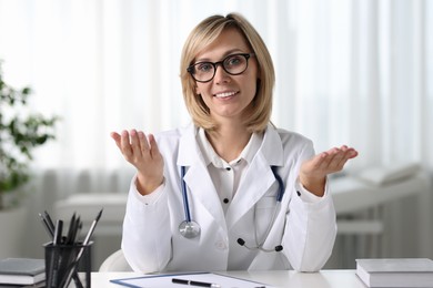 Portrait of smiling doctor at table in office