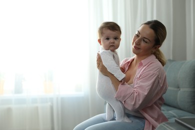 Photo of Young woman with her cute baby at home. Space for text